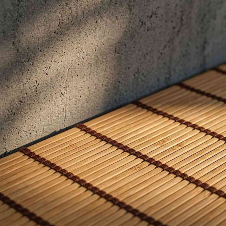 Bamboo mat on a concrete wall in the sunlight. Selective focus.