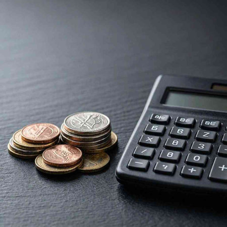 Calculator and coins on a black background. Financial concept.