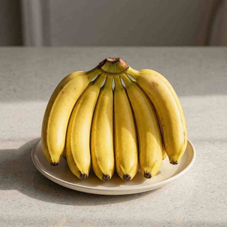 Bunch of bananas on a white plate on a gray background.