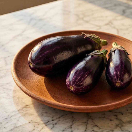purple eggplants on a wooden plate on a marble table
