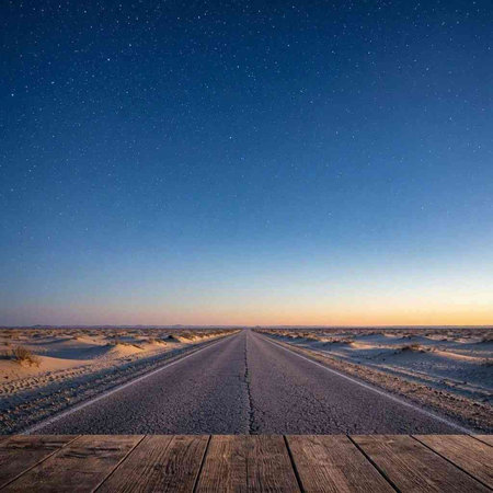 desert road at night with starry sky in the background.