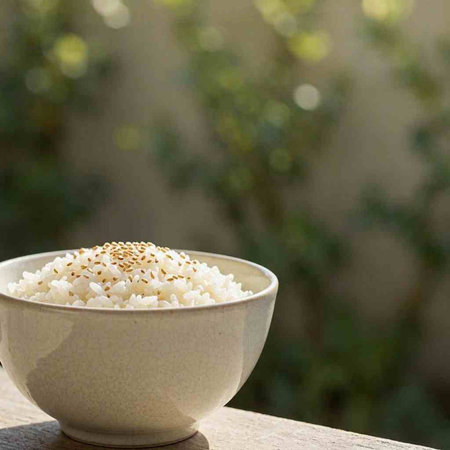 Bowl of rice with sesame seeds on a wooden table.