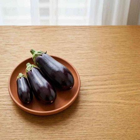 Eggplant in a ceramic plate on a wooden table. Copy space.