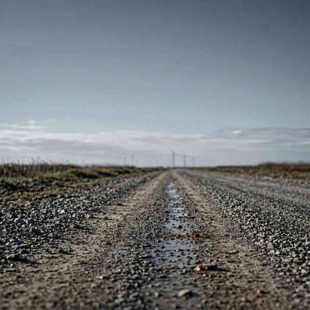 A closeup shot of a road in the middle of a field