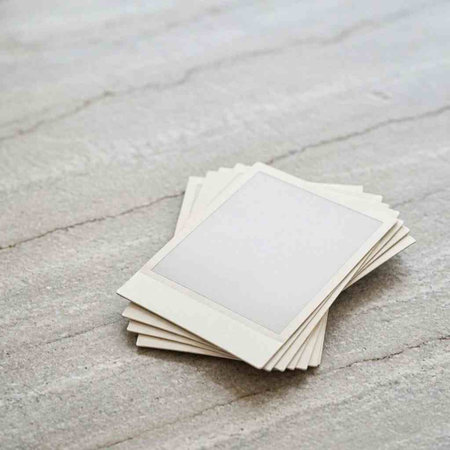 Blank photo frame on white wooden background with copy space for your text.