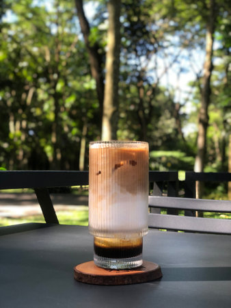 Iced coffee in a glass on the table in the garden.の写真素材
