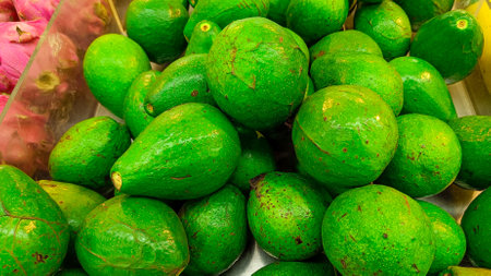 High Angle View of Fresh green avocados on display in the fruit marketの写真素材