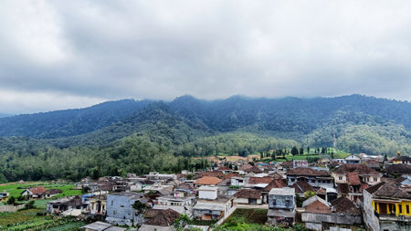 panoramic of village houses with mountains and blue sky in the backgroundの写真素材