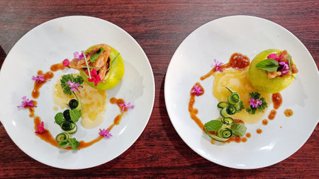 Two Plate of vegetable salad in citrus fruit with sauce and cucumber garnishの写真素材