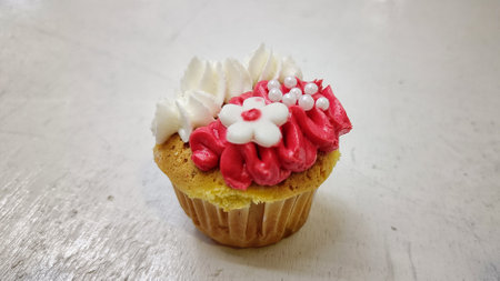 Close Up Delicious Cupcake with red and white cream topping and candy sprinklesの写真素材