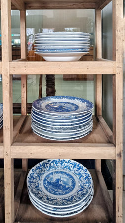 Pile of Antique plate with unique decoration in wooden rackの写真素材