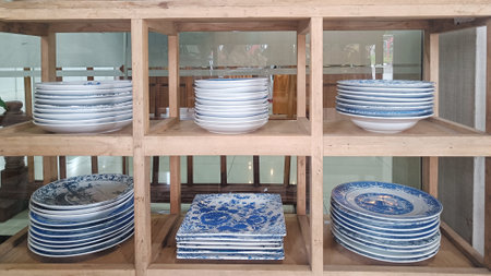 Pile of Antique plate with unique decoration in wooden rackの写真素材