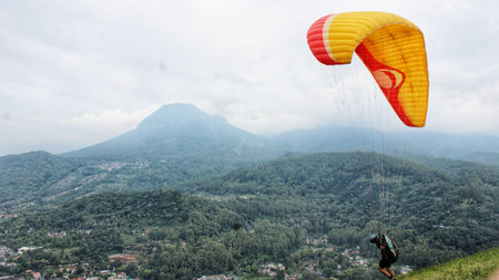 Paraglider pilot flying after taking off from a hillの写真素材