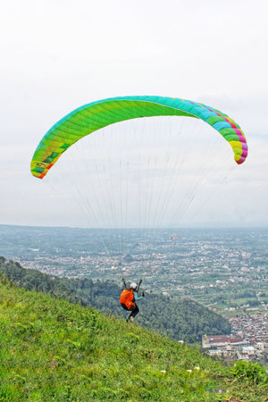 Paraglider pilot flying after taking off from a hillの写真素材