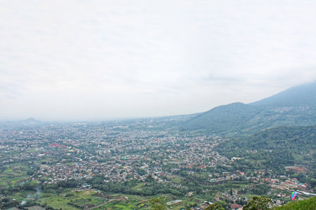 village view at the foot of mountains and hills with blue sky and white cloudsの写真素材