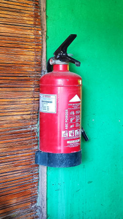 Fire extinguisher system on the green wall background, powerful emergency equipmentの写真素材