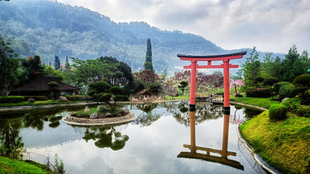 Japanese red torii gate beside lake with beautiful hills and blue skyの写真素材