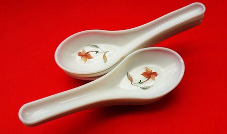 crockery spoon isolated on red backgroundの写真素材