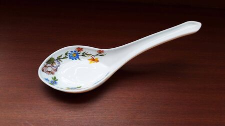 crockery spoon isolated on brown background close imageの写真素材