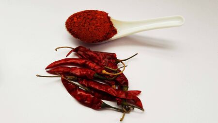 indian spice chili and its powder in spoon isolated on white background
