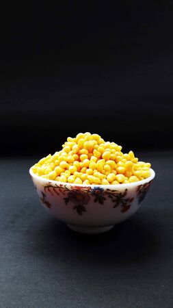 fresh and healthy deep fried gram flour balls in bowl isolated on black background
