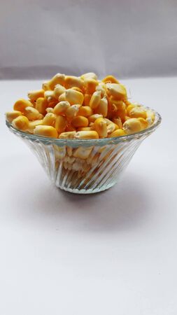 healthy raw sweet corn in bowl isolated on white background
