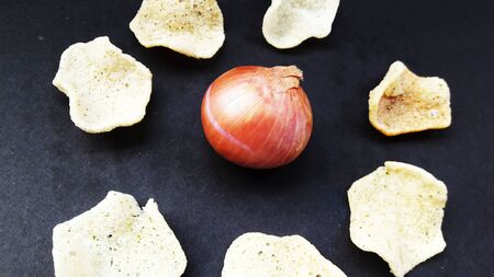 onion rice chips with onion in middle isolated on black groundの写真素材
