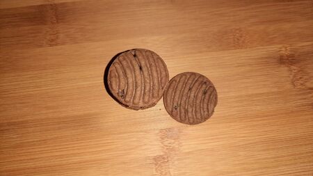 brown chocolate cookies isolated on wooden backgroundの写真素材