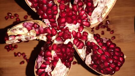 pomegranate and its seeds on wooden backgroundの写真素材
