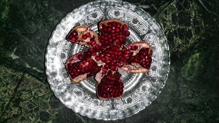 pomegranate seeds on green background