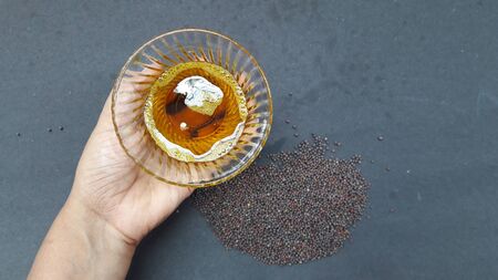 mustered seed and oil in bowl isolated on black backgroundの写真素材