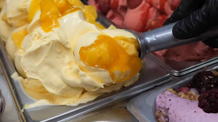 Ice cream with mango and berries in ice cream shop, close up