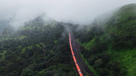 Aerial view of a train moving through a foggy valley in Sri Lanka
