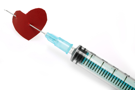 paper heart on a needle of syringeの写真素材