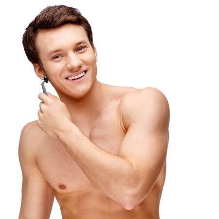 Handsome young man sniffing his armpit isolated on whiteの写真素材
