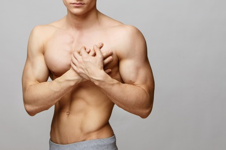 Studio shot of a young muscular man with pain problemsの写真素材