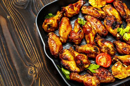 roasted chicken wings with herbs on wooden tableの写真素材