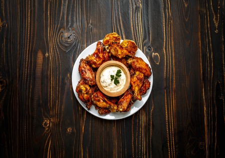 roasted chicken wings with herbs on wooden tableの写真素材