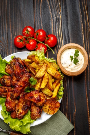 roasted chicken wings with herbs on wooden tableの写真素材