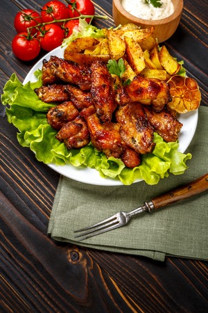 roasted chicken wings with herbs on wooden tableの写真素材