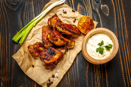 roasted chicken wings with herbs on wooden tableの写真素材