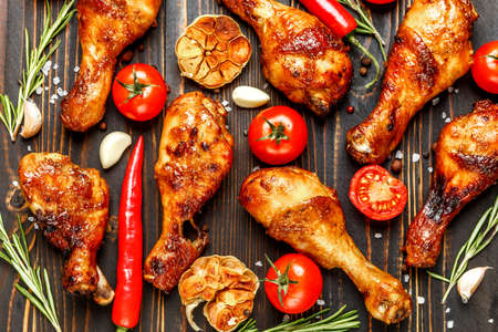 roasted chicken legs with herbs on wooden tableの写真素材