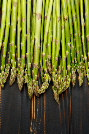 bundle of harvested fresh asparagus wooden backgroundの写真素材