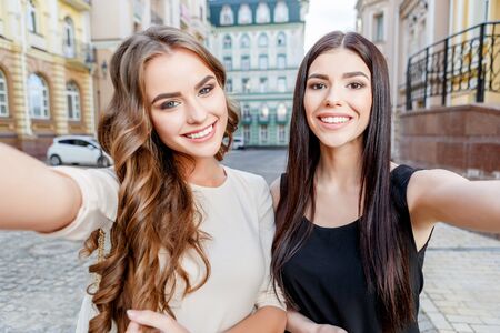 happy young caucasian women with shopping bags outdoorの写真素材