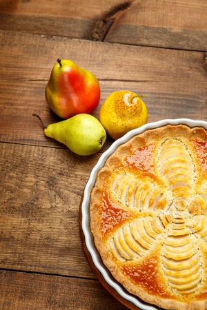 Beautiful fresh organic pear tart on wooden backgroundの写真素材