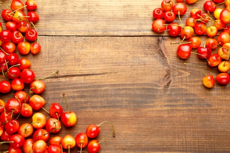 Studio shot of fresh natural cherries on wooden background