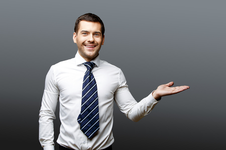 Handsome stylish caucasian businessman on grey background with copy spaceの写真素材
