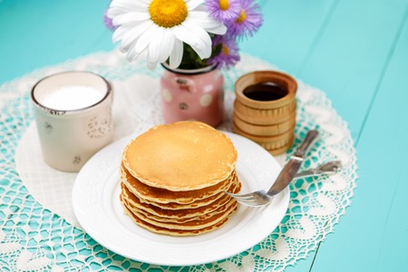 Stack of homemade pancakes on wooden background