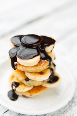 Delicious homemade cheese pancakes with raisins on rustic wooden tableの写真素材