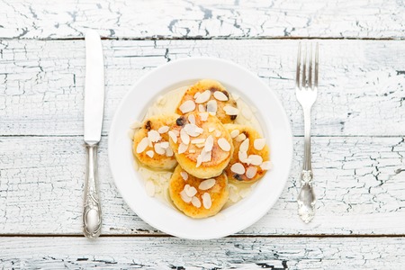 Delicious homemade cheese pancakes with raisins on rustic wooden tableの写真素材